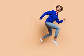 Sticker - Full body profile photo of active sporty lady look back empty space jump run isolated on beige color background