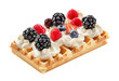 Dessert in the shape of a rectangular waffle, topped with whipped cream and forest fruits.