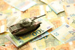 Many euro banknotes and tank. Lot of bills of European union currency and green tank close up