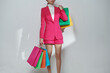 © Marc Tran/Stocksy - Cropped shot of female hand holding bunch of different colorful bags