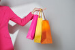 © Marc Tran/Stocksy - Cropped shot of female hand holding colorful paper shopping bags