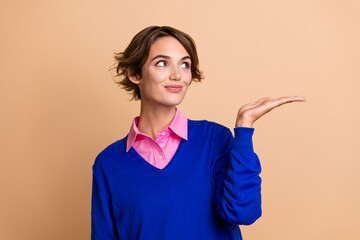 Sticker - Photo portrait of pretty young girl palm hold look empty space dressed stylish blue outfit isolated on beige color background