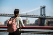 © David Prado/Stocksy - Woman observing Manhattan bridge from waterfront