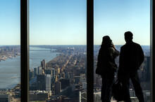 Man and woman overlooking expansive Manhattan view