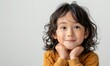 Serene Chinese girl gazes thoughtfully, framed by soft studio hues