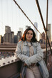© Pedro Merino/Stocksy - woman strolling on the Brooklyn Bridge at sunset
