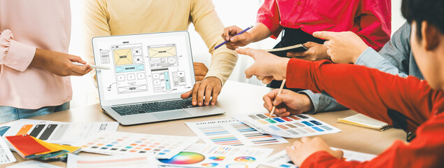 Cropped image of interior designer team discuss the material color while laptop displayed website wireframe designs for mobiles app and website. Creative design and business concept. Variegated.