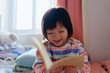 © Pansfun Images/Stocksy - little girl leisurely learning to read
