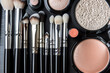 Flawlessly organized flat lay of makeup brushes, powders, and compacts, showcasing neatness and elegance.