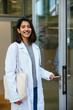 © BONNINSTUDIO/Stocksy - Female doctor with bag at hospital outdoors