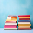 © Wazir Design - Stack of colorful books on blue background. Back to school concept.