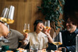 © Studio Firma/Stocksy - Group of people toasting in restaurant