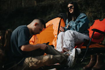 Wall Mural - Group of friends relaxing and bonding on a camping adventure in the wilderness, representing friendship and leisure.