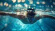 A man is having fun swimming underwater in the aqua electric blue swimming pool