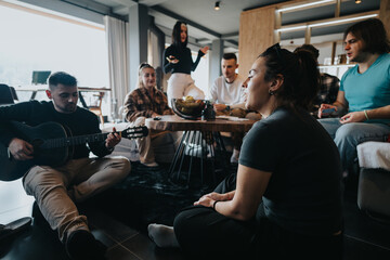 Poster - A group of friends relax and have fun as one plays the guitar in a comfortable home atmosphere