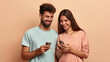 A man and a woman engrossed in their smartphones, lost in the digital world, disconnected from each other, young smiling happy couple two friends family man woman wear casual clothes hold in hand use 