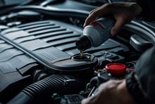 A Hand Holding An Oil Bottle And Filling It In The Engine Compartment