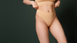 © looking2thesky - Body Shaping Spa And Slimming. Closeup cropped of unrecognizable fit woman wearing lingerie pulling up white panties standing on studio background. Torso of slim female with lines