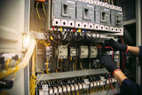 Fototapeta Mapy - Electricity and electrical safety maintenance service system, Technician hand checking electric current voltage at circuit breaker terminal and cable wiring in main power distribution board.