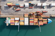 © DedMityay - Top down aerial view of cargo ship loading containers. Showcases maritime shipping efficiency. Part of global distribution network.