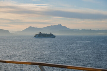 Super deluxe luxury cruiseship cruise ship liner yacht Europa 2 sailing towards Palermo, Sicily during Mediterranean cruise with breathtaking sunrise and coastal landscape