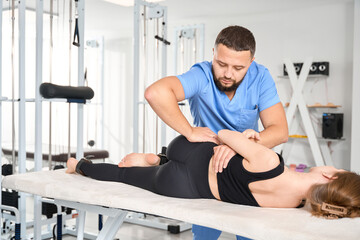 Wall Mural - Osteopath works with the spine of a young woman