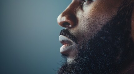 Wall Mural - side view profile portrait of  a black man with a long full beard on a studio background