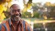 © Keitma - Black afro american man in his 50s who exudes happiness and a sense of feeling truly alive in a beautiful natural park near a lake, genuine smile on his face, relaxed and confident male who found joy