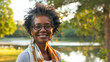 © Keitma - Black american woman in her 50s who exudes happiness and a sense of feeling truly alive in a beautiful natural park near a lake, genuine smile on her face, relaxed and confident, female who found joy