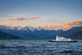 Fototapeta  - Ferry on Lake Como, Italy with snow covered mountains in the background
