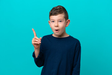 Wall Mural - Little kid boy isolated on blue background intending to realizes the solution while lifting a finger up