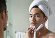 Man wiping face with towel Skincare Image colorful background