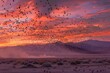 : A large, majestic flock of birds soaring above a vast desert, with a stunning mix of warm and cool colors in the background