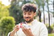 © luismolinero - Young Arabian handsome man holding a bowl of fruit at outdoors