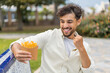 © luismolinero - Young Arabian handsome man holding fried chips at outdoors celebrating a victory