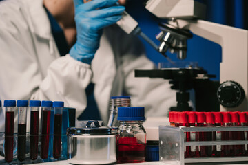 Team of biochemical research scientists working with a microscope for vaccine development in pharmaceutical research labeling.