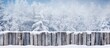 Snow covers the ground around an old wooden fence, creating a perfect background for winter concepts or projects