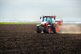 Fototapeta Panele - Tractor spreading artificial fertilizers