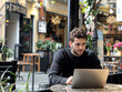 © Deea Journey  - Entrepreneur man working on laptop in a modern cafe shop, remote worker / digital nomad