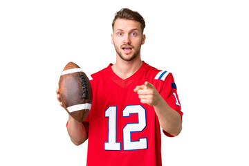 Wall Mural - Young caucasian man playing rugby over isolated chroma key background surprised and pointing front