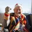 Cheerful elderly man in a colorful blanket