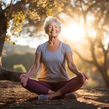 Smiling Elderly Woman Meditating In A Park