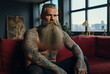 Attractive hipster man with a mustache beard and tattoos, a Fierce and formidable appearance