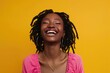 Attractive Young Woman. Happy African American Woman Smiling and Laughing in Colorful Clothes on Yellow Background