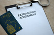 Passport of Canada and Extradition Agreement with handcuffs on table close up