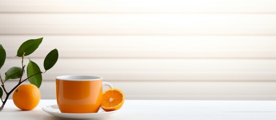 Wall Mural - A liquid drink in an amber drinkware with slices of oranges and leaves served on a saucer on a table