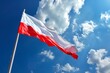 Flaga Polski powiewająca na tle błękitnego nieba.