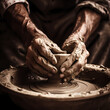 A pair of hands molding clay on a potters wheel. 