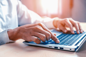 Wall Mural - businessman hand typing on computer keyboard of a laptop computer in office. business and finance co
