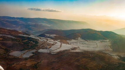 Wall Mural - Aerial view of a solar photovoltaic field situated atop a mountain range